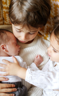 Deux enfants avec un bébé.